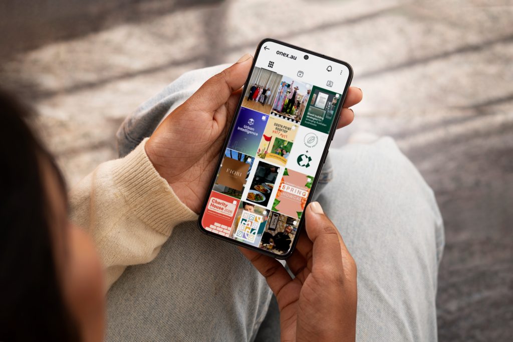 Image of a person holding a smartphone looking at the one x Instagram page